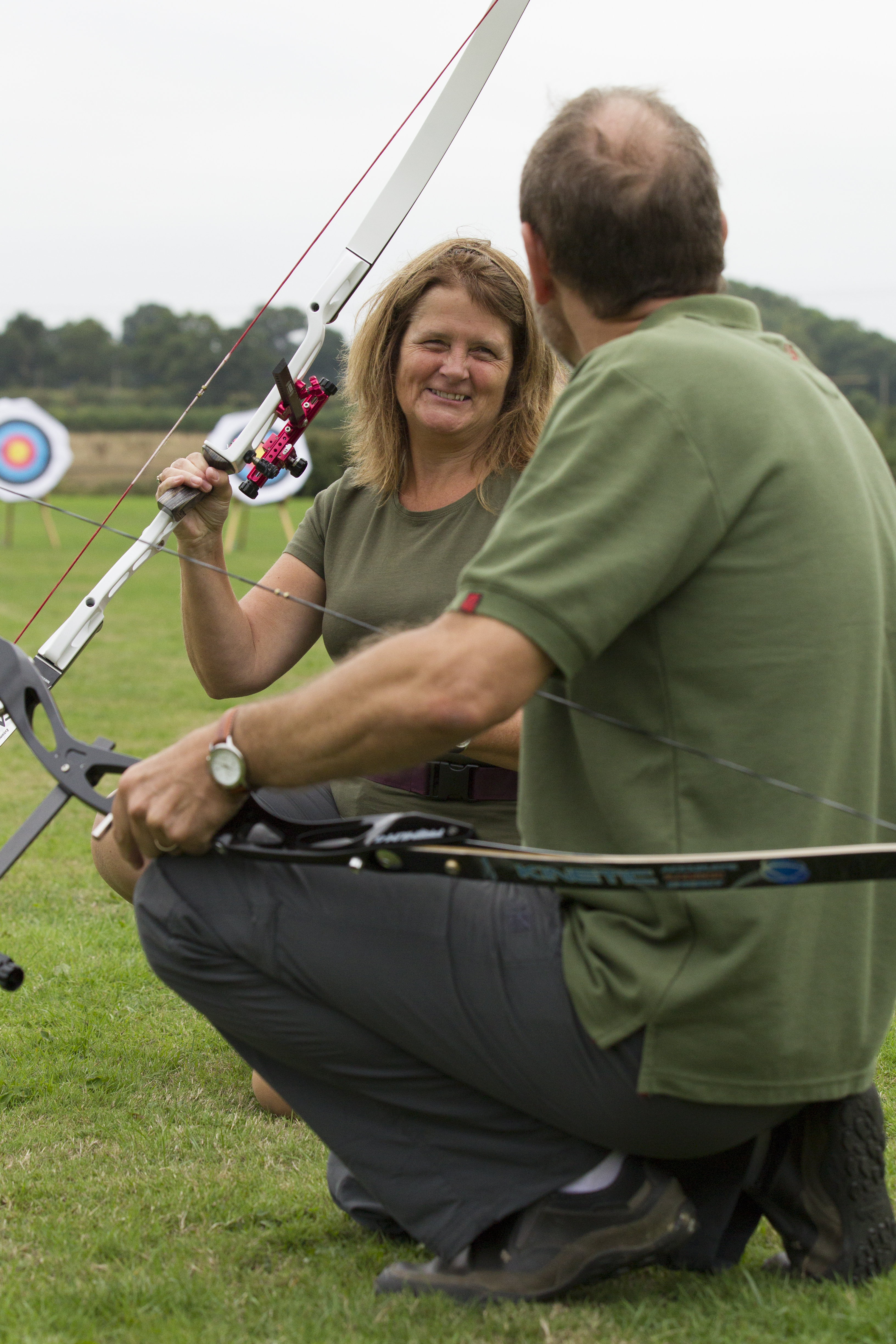 People talking holding archery equipment