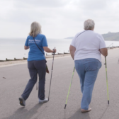 two ladies walking with nordic poles on coast